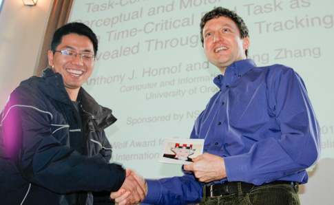 Yengfun laughs as Anthony surprises him with with an award before Yunfeng's presentation.